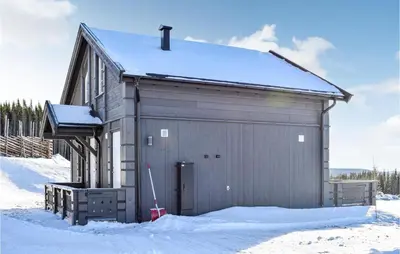 a large metal building with snow on the ground at Amazing Home In Mesnali With Wifi in Mesnali