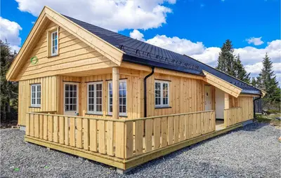 a large wooden cabin with a solar roof at 3 Bedroom Amazing Home In Sjusjøen in Sjusjøen