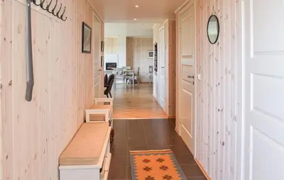 a hallway with a bench and a dining room at Nice Home In Sjusjøen With Kitchen in Sjusjøen