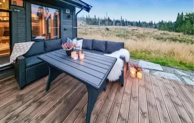a blue couch and a table on a deck at Lovely Home In Lillehammer With Kitchen in Lillehammer
