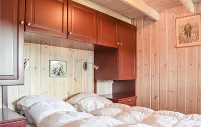 a bedroom with wooden walls and a bed and cabinets at Sjusjøen Pihl 4001 in Sjusjøen