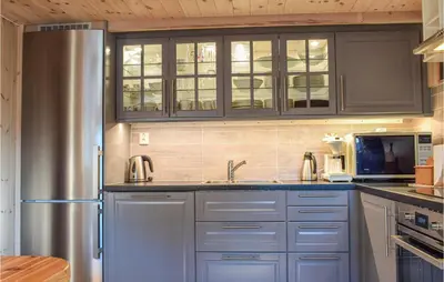 a kitchen with blue cabinets and a stainless steel refrigerator at Sjusjøen Pihl 4001 in Sjusjøen