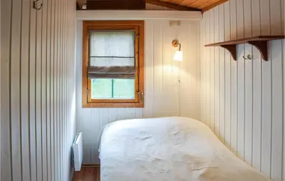 a small bedroom with a bed and a window at Nice Home In Sjusjøen With Wifi in Sjusjøen