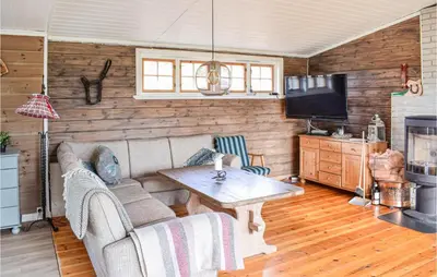 a living room with a couch and a table at Cozy Home In Sjusjøen in Sjusjøen