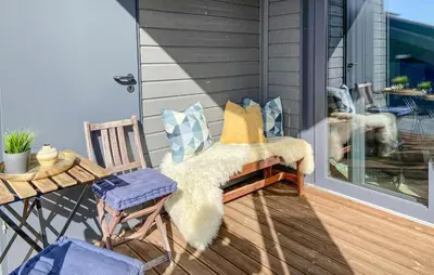a porch with a bench and a table and a dog at Leil 70 in Sjusjøen