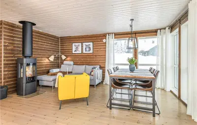 a living room with a fireplace and a table and chairs at 4 Bedroom Amazing Home In Lillehammer in Lillehammer