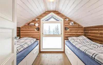 two beds in a room with a window at 4 Bedroom Amazing Home In Lillehammer in Lillehammer