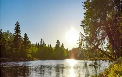 a river with the sun reflecting on the water at 4 Bedroom Cozy Home In Sjusjøen in Sjusjøen