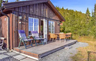 a cabin with chairs and a table on a deck at Stunning Home In Etnedal With Kitchen in Etnedal