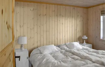 a bedroom with a large white bed and two lamps at Stunning Home In Etnedal With Kitchen in Etnedal