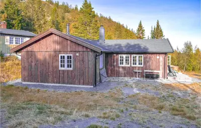 a large wooden building in a field at Stunning Home In Etnedal With Kitchen in Etnedal