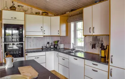a kitchen with white cabinets and a black counter top at Stunning Home In Etnedal With Kitchen in Etnedal