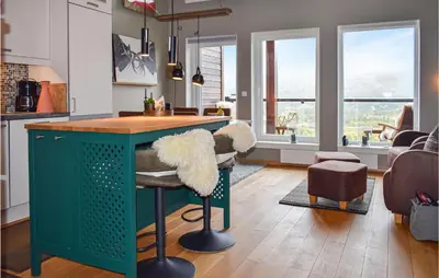 a kitchen with a green island with a stool at 2 Bedroom Cozy Apartment In Geilo in Geilo