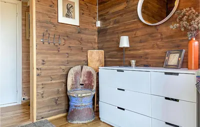 a bathroom with a wooden wall with a toilet in it at 3 Bedroom Awesome Home In Eggedal in Eggedal