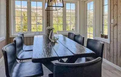 a dining room with a wooden table and chairs at 4 Bedroom Awesome Home In Eggedal in Eggedal