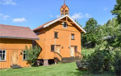 an orange building with a clock tower on top of it at Bjertnes Turistgård in Noresund