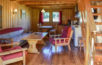 a living room with a table and chairs and a kitchen at Bjertnes Turistgård in Noresund