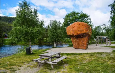 a picnic table and a large sculpture next to a river at Stunning Apartment In Hemsedal in Hemsedal