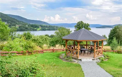 a gazebo with a table and chairs in the grass at Bjertnes Turistgård in Noresund