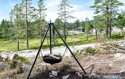 a basket hanging from a tripod in a field at Beautiful Home In Flå With Kitchen in Flå