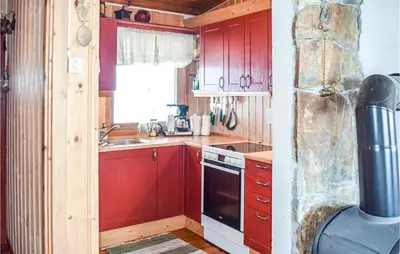 a kitchen with red cabinets and a sink and a stove at 2 Bedroom Beautiful Home In Gol in Gol