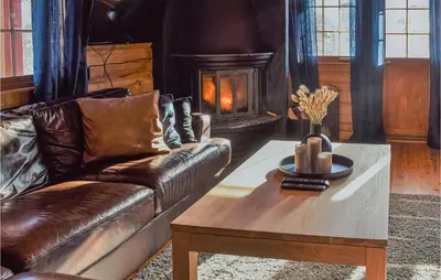 a living room with a leather couch and a coffee table at Cozy Home In Hovden I Setesdal in Hovden