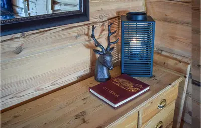a table with a book and a statue of a deer head at Cozy Home In Hovden I Setesdal in Hovden
