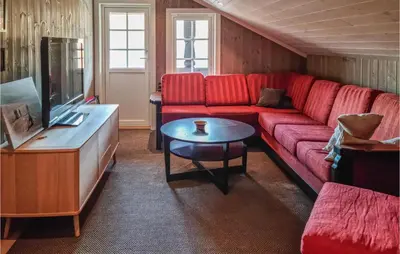 a living room with a red couch and a table at Stunning Home In Hovden I Setesdal in Hovden