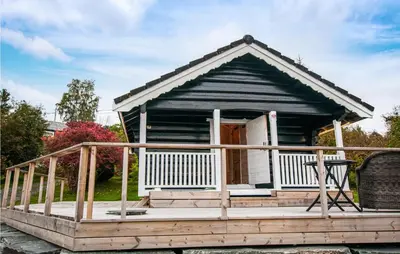 a small house with a wooden deck with a door at Stunning Home In Frosta