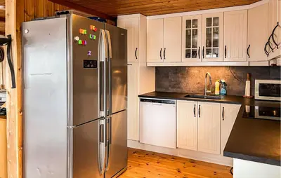 a kitchen with a stainless steel refrigerator and white cabinets at Nice Home In Malm With Lake View in Malm