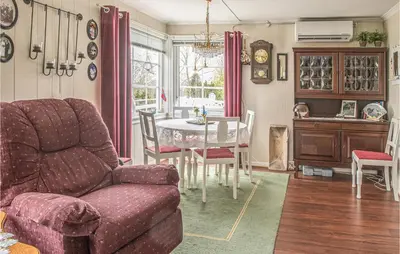 a living room with a couch and a table and chairs at Amazing Home In Ytterøy With Wifi