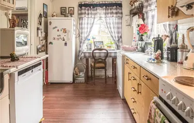 a kitchen with a white refrigerator and a table at Amazing Home In Ytterøy With Wifi