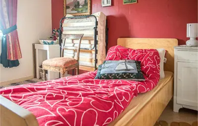 a bedroom with a bed with a red wall at Amazing Home In Ytterøy With Wifi