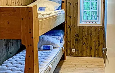 two bunk beds in a room with a window at Nice Home In Beitstad With Kitchen in Sunnan