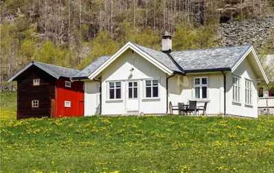 a red and white house in a field of flowers at Nice Home In Hemsedal With Sauna in Hemsedal