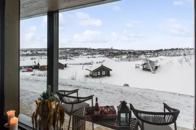 a view of a snow covered field from a window at Kikut Alpine Lodge 9103 in Geilo