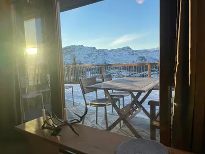 a table and chairs on a balcony with a view of mountains at Gaustatoppen Lodge - Mountain View - Gaustablikk in Rjukan