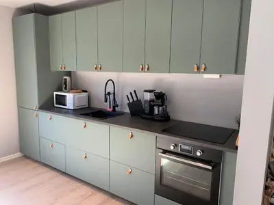 a kitchen with white cabinets and a microwave at Trolltunga Panorama in Tysso