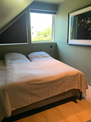 a bedroom with a large bed with a window at Trolltunga Panorama in Tysso
