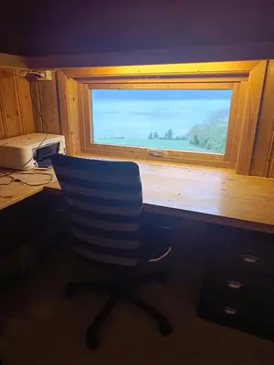a desk with a chair in front of a window at Randsfjord house in Gran