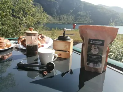a table with a cup of coffee and pastries on it at Reinunga Eco Hytta - Mountain lodge near Myrdal accessible only by train or bike in Myrdal