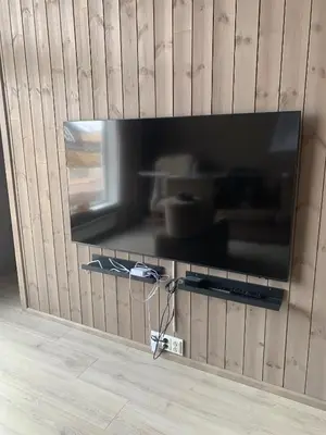 a flat screen tv hanging on a wooden wall at Koselig hytte - Trysilfjellet ski in og ski out 4 soverom, 2 bad, badstue, fiber bredbånd og Elbillader in Trysil