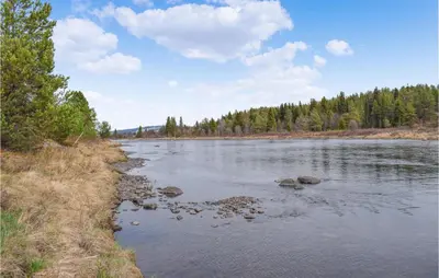 a river with rocks in the water and trees at Amazing Home In Tisleidalen With Sauna in Hovda