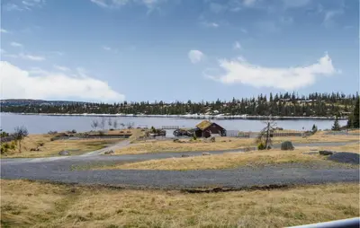 a view of a lake with a barn and a house at Fjellheimen Nr 104 in Sjusjøen