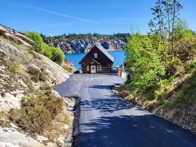 a house on the side of a road next to a lake at 6 person holiday home in Urangsvåg-By Traum in Ervik