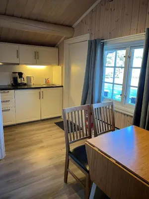a kitchen with a table and two chairs and a table and a window at Fagernes Camping in Fagernes