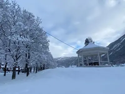 a gazebo in the snow next to some trees at Tveitopark Apartments A in Rjukan