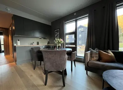 a kitchen and living room with a table and chairs at Snøya Lodge in Hemsedal
