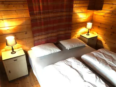 two twin beds in a room with two lamps at Solvang World Heritage Camping in Eidsdal