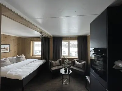 a hotel room with a large bed and a couch at Lisletun in Hovden